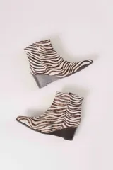 Botas cortas con estampado animal print de cebra, con taco de cuña y punta fina.