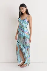 Vestido largo con estampado floral multicolor, escote en V, breteles finos y volados asimétricos.