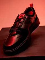 Championes urbanos de edición limitada inspirados en Darth Vader, confeccionados en cuero negro con detalles en rojo. Presentan el logo de Star Wars en la lengüeta y un diseño minimalista con cordones.