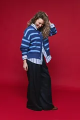 Cardigan tejido a rayas horizontales en tonos azul y celeste, con cuello redondo, hombros caídos y cierre frontal con botones.