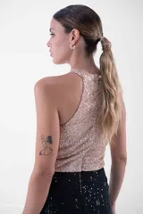Vestido largo con cuello halter enteramente cubierto de lentejuelas, que combina un cuerpo superior en tono rosado y una falda larga en color negro.