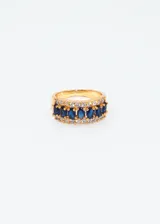 Anillo dorado con zirconias azules y blancas.