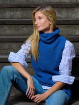 Chaleco de punto sin mangas en color azul vibrante, con cuello alto tipo polera y diseño de tejido con textura acanalada vertical.