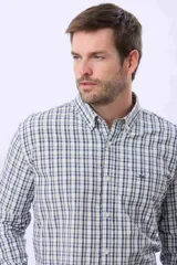 Camisa de manga larga con estampado de cuadros en tonos azules, verdes y blancos. Presenta cuello clásico con botones, cierre frontal abotonado y un pequeño logo bordado en el pecho.