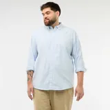 Camisa de corte recto confeccionada en tejido oxford de algodón, color celeste claro. Presenta cuello abotonado, cierre frontal con botones y mangas largas con puños abotonados.
