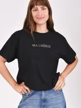 Remera negra de corte cropped con estampado frontal de la frase 'Ma Chérie' en letras plateadas.