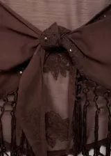 Falda corta pareo de color marrón semitransparente, con bordados florales, detalles de lentejuelas y terminación de flecos. Cuenta con un cierre de nudo en la parte frontal.