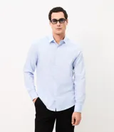 Camisa de corte regular para hombre, en color celeste con finas rayas verticales blancas. Cuenta con cuello camisero tradicional, mangas largas con puños abotonados y cierre frontal con botones.
