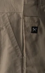 Bermuda tipo cargo color beige, con bolsillos laterales con solapa, trabillas para cinto y cierre frontal con botón y cremallera.