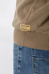 Sweater marrón con cuello mao abotonado y detalle de tejido en los hombros.