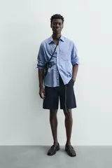 Bermuda de hombre color azul marino, de corte relajado (relaxed fit), confeccionada en tejido con textura. Presenta bolsillos frontales y bolsillos traseros de vivo, con cierre frontal de cremallera y botón.