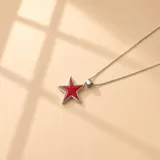 Collar de cadena fina de plata 925 con dije en forma de estrella, con centro de resina color azul oscuro y borde plateado.