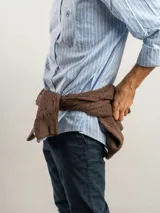 Camisa de corte regular confeccionada en tejido Oxford de algodón, con diseño de rayas verticales finas. Presenta cuello abotonado, cierre frontal con botones y un bolsillo en el pecho.