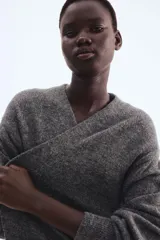 Saco largo de punto fino color gris oscuro, con lana en la trama. Diseño sin cierre, con hombros caídos y ribete acanalado en nuca, puños y bajo.