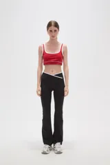Top deportivo negro con detalles de ribete blanco en el escote y breteles. Presenta un diseño de corte cuadrado y ajuste al cuerpo.