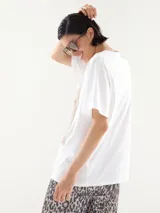 Remera blanca de corte recto con estampa de dos perros caniches vestidos con abrigos.