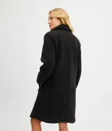 Campera alargada de sherpa color verde manzana, con cuello solapa, cierre cruzado con botones y bolsillos delanteros.