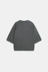 Sudadera de cuello redondo en color rosado, con mangas cortas amplias y estampa frontal con texto en color negro.