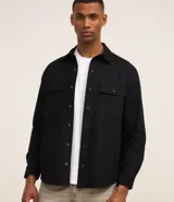 Camisa de manga larga para hombre, confeccionada en sarga de algodón, con cuello inglés, abotonado frontal y dos bolsillos con solapa en el pecho.