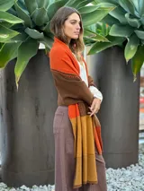 Pashmina de lana con diseño de bloques de color en gris oscuro, gris claro, blanco y negro. Presenta costuras decorativas en contraste.