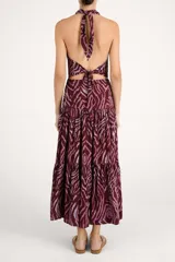 Vestido largo bordó con estampado animal print abstracto en tonos rosados, con cuello halter y falda escalonada con volados.