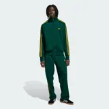 Campera deportiva Adidas Firebird de color verde oscuro con textura de rayas de tiza y detalles en amarillo, incluyendo las clásicas tres tiras en las mangas y el logo del trifolio bordado en el pecho. Cuenta con cuello alto, cierre frontal completo y bolsillos laterales.