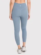 Calza deportiva de tiro alto y largo ankle, confeccionada en tejido suave con tecnología seamless que minimiza las costuras. Presenta un diseño liso y ajustado, ideal para actividades de alto rendimiento.
