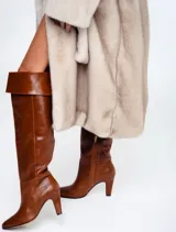 Bota de cuero color marrón con taco y caña alta.