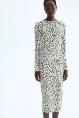 Vestido midi entallado de punto con estampado de leopardo, cuello redondo, manga larga y espalda descubierta con detalle cruzado en la cintura.