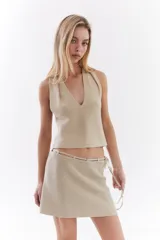 Top bordó de punto con lurex, escote en V profundo estilo halter y diseño sin mangas.
