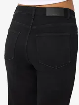 Jeans flare de tiro alto, color negro, con diseño acampanado en las piernas y cierre frontal de botón y cremallera.