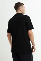 Remera polo gris de manga corta con cuello clásico y tapeta de dos botones.