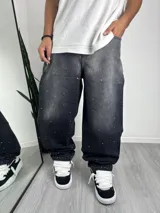 Pantalón de jean corte baggy, color negro con efecto lavado y apliques de strass distribuidos por toda la prenda.