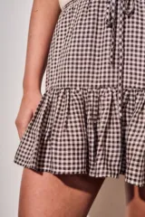 Minifalda con estampado de cuadros vichy en tonos marrón y blanco, con cintura elástica fruncida, cordón ajustable y volado en el ruedo.