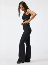 Calza flare negra con corte acampanado y cintura en forma de V.