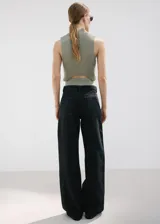 Pantalón de jean negro de corte recto y tiro alto, con diseño clásico de cinco bolsillos y cierre frontal con botón y cremallera.