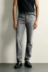 Jeans slim fit de color negro para hombre, con tiro medio, diseño de cinco bolsillos y cierre frontal con cremallera y botón.