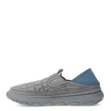 Championes tipo mocasín slip-on Merrell Hut Moc 2, color gris con diseño acolchado tipo matelassé. Presenta talón colapsable, suela de EVA ligera y detalles en azul en la parte posterior.