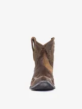 Bota corta estilo cowboy de cuero marrón desgastado, con punta afilada y tacón bajo. Presenta bordados en hilo dorado en el empeine y caña, incluyendo un diseño de estrellas troqueladas en la puntera. El tacón tiene un acabado envejecido plateado.