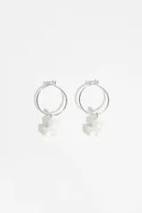 Aros de tipo argolla plateada con un dije colgante en forma de perrito realizado en resina con acabado perlado.