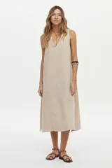 Vestido midi color crudo de corte relajado, con caída fluida, sin mangas y escote en V.