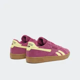 Championes Reebok Court Retro color borgoña con detalles en amarillo y suela marrón.