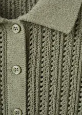 Chaleco de punto verde militar con diseño texturizado, cuello camisero, manga corta y cierre parcial de botones en la parte delantera.