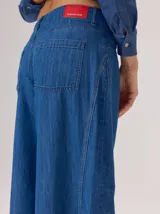 Pantalon de jean ancho, de corte holgado y fluido desde la cadera hasta el tobillo, con costuras verticales decorativas en el frente.