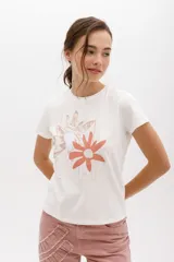Remera blanca de algodón con estampado de dos flores en tonos pastel y logo de la marca en cursiva. Corte clásico y cuello redondo.