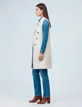 Chaleco largo tejido color blanco de la marca Sioni, con cuello solapa, doble botonadura dorada en el frente y bolsillos aplicados.