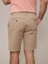 Bermuda azul marino de gabardina, corte recto, con bolsillos laterales y traseros.