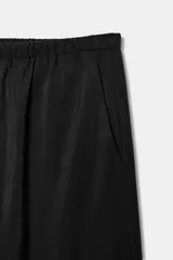 Pantalón negro de tiro medio, con cintura elástica y cordón ajustable. Tiene bolsillos delanteros y bajo ajustable con cordones del mismo tejido.