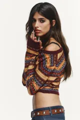 Chaqueta corta de punto con diseño jacquard multicolor, cuello redondo, manga larga y cierre frontal con botones.