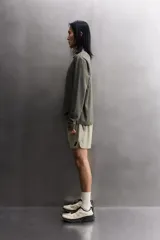 Camiseta de entrenamiento regular fit color gris oscuro, confeccionada en tejido técnico ligero y elástico con estructura. Cuenta con cuello redondo, manga larga y logo estampado en el bajo.